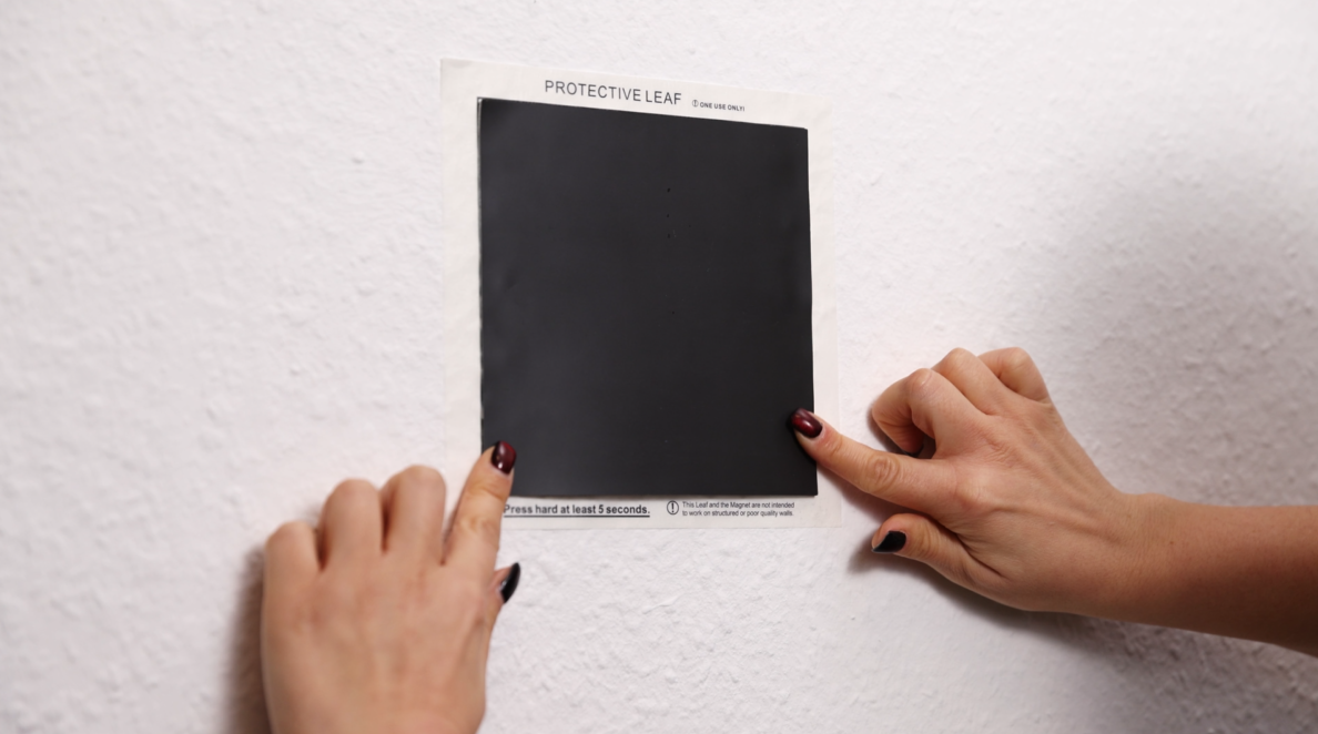 Rahmen mit Magneten an die Wand drücken